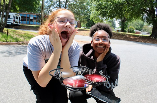 Students working with drones and robots outside a Betabox mobile lab